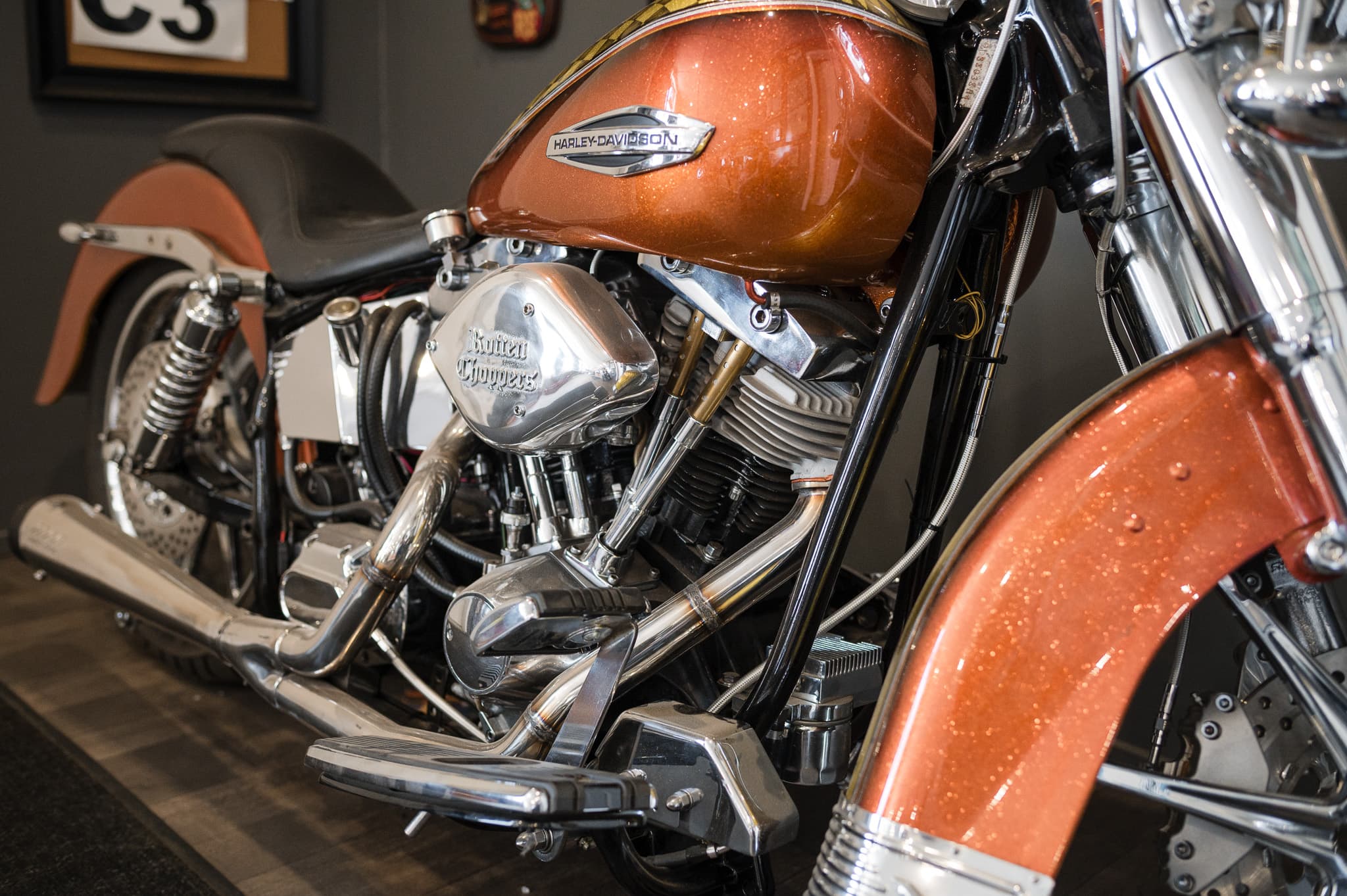 Close-up of a copper-painted Heritage Springer engine: chrome rocker boxes, dual exhaust, and metalflake paint